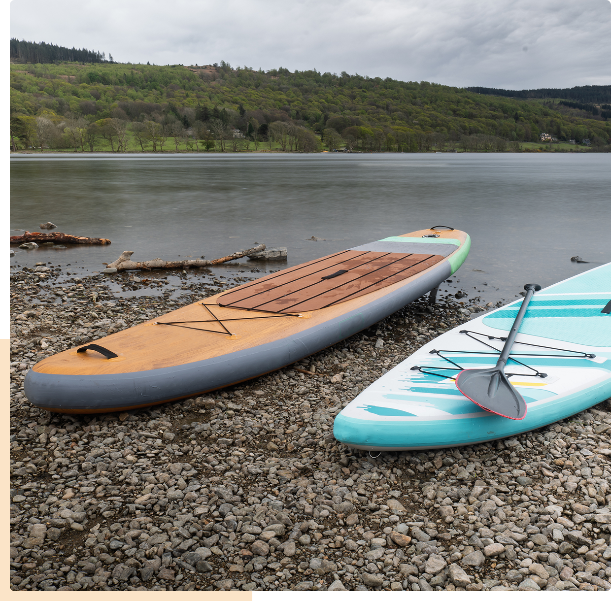 Two paddleboards on a rocky lakeshore.
