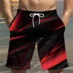 Men's swim trunks with a red and black abstract design and white drawstring.