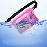 A pink waterproof pouch partially submerged in water with a phone inside.