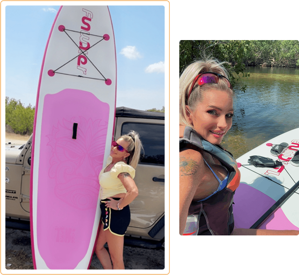 Woman holding a pink paddleboard near water, smiling.